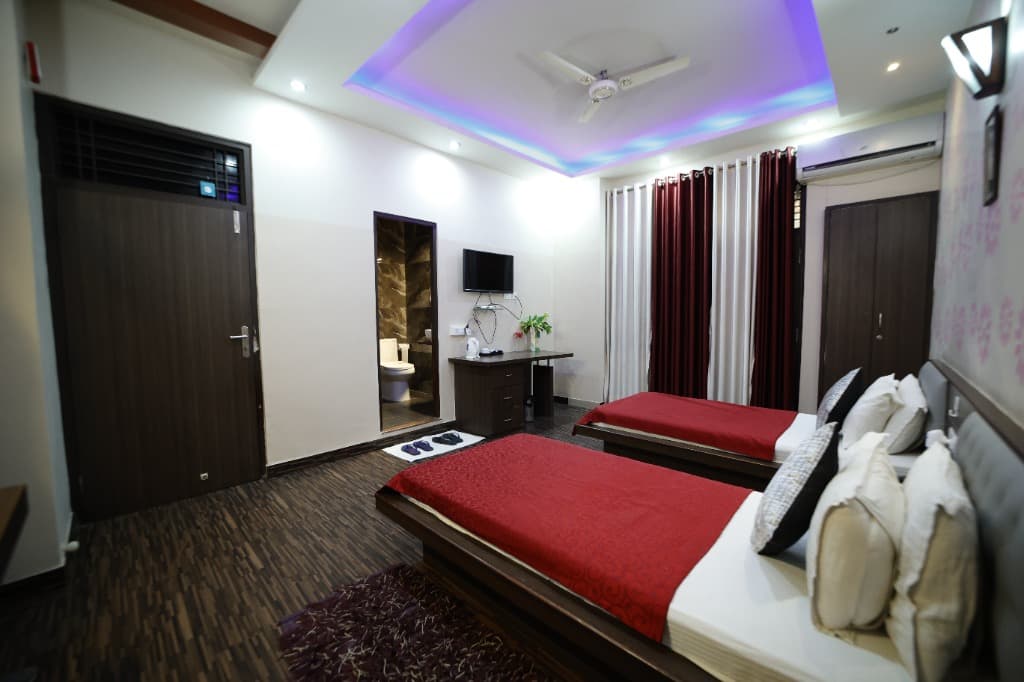 Deluxe Twin Room with purple LED ceiling and red bedcovers at Hotel Park Avenue Sikar